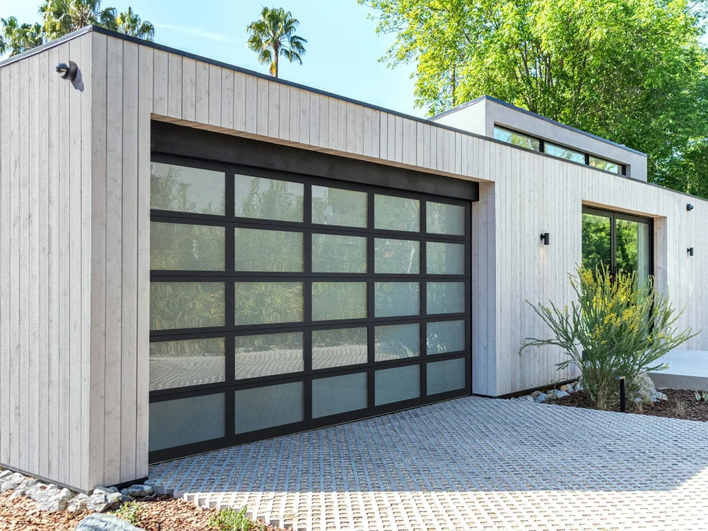 contemporary home featuring light vertical wood siding and a textured paver driveway, highlighting the Best Garage Door Designs in Kirkland, WA