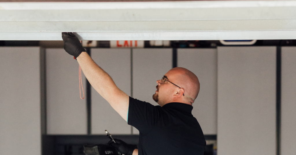 Technician pulls red cord on garage door.