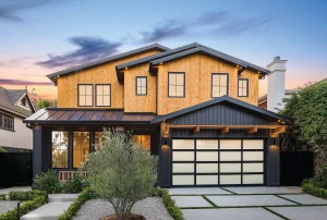 A stunning two-story modern home featuring natural wood siding and a black-framed frosted glass garage door, illustrating an upscale design often protected by modern garage door locks.